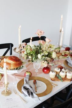 the table is set with cupcakes, apples, and other desserts on it