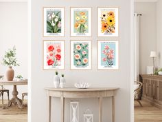 there are four framed pictures on the wall above a table with vases and flowers