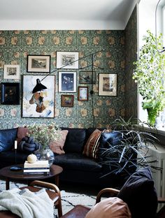 a living room filled with furniture and pictures on the wall