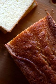 two pieces of bread sitting on top of a wooden cutting board next to each other