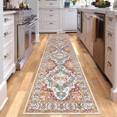 a long rug in the middle of a kitchen with white cabinets and an area rug on the floor