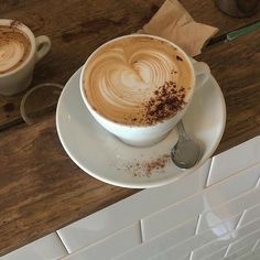 two cups of cappuccino on a wooden table