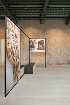 an empty room with large posters on the wall and flooring in front of it