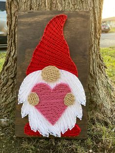 a wooden sign with a red and white heart in the shape of a santa clause