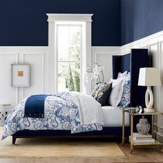 a bedroom with blue walls and white furniture