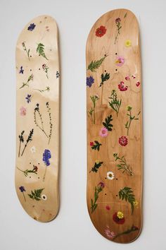 two wooden skateboards with flowers painted on them