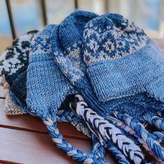 three knitted hats sitting on top of a wooden table