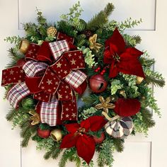 a christmas wreath with poinsettis, bells and greenery on the front door