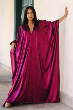 Introducing the Rudy Kaftan from our Regal Collection, an exquisite piece crafted from a glossy ruby fabric. With its multiple arm holes and V neck, you can style this garment your way for an effortless, sophisticated look. Our model is 5'6, and is wearing our One Size Fits All. We offer world wide international shipping as well as local Trinidad & Tobago shipping and pick up options. 96% Rayon 4% Spandex Hand wash cold, air dry All orders are currently being shipped out of Trinidad & Tobago. Fancy Kaftan, Silk Caftan, Prayer Dress, Kaftan Styles For Ladies, African Kaftan Dress, Jewish Women Fashion, Night Gown Dress, Kaftan Designs, Kaftan Style