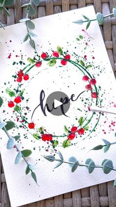 a piece of paper with the word hope painted on it, surrounded by leaves and berries