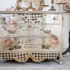 an old dresser with roses painted on it and gold trim around the top, along with other antique furniture