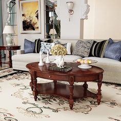 a living room with a couch, coffee table and pictures on the wall behind it