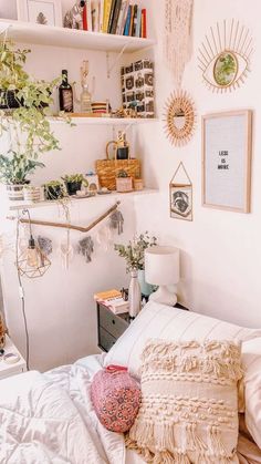 a bed with white sheets and pillows in a bedroom next to a bookshelf