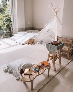 a bed with a teepee on top of it next to a table and chair