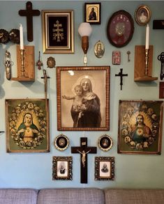 a living room wall with pictures and crosses on it