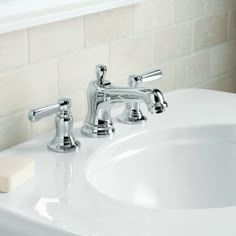 a bathroom sink with two faucets and soap dispenser