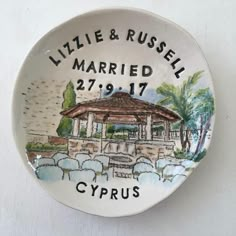 a white plate with a drawing of a gazebo and the words, little & russell married 27 / 19 / 17 cyprus