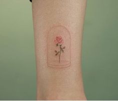 a rose in a glass jar tattoo on the arm