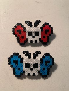 two pieces of pixel art made to look like pacman and mushroom head brooches