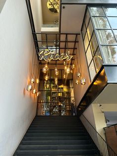 the stairs leading up to a restaurant with chandeliers hanging from it's ceiling