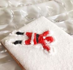 a cookie decorated with white icing and red black and white snowman on it