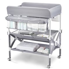 a baby changing table with two trays on it's sides and three diapers in the middle