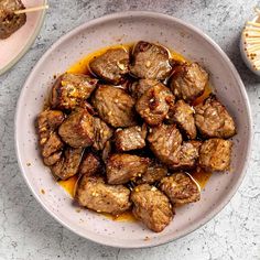 a white plate topped with meat covered in sauce