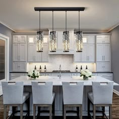 a large kitchen with white cabinets and gray chairs