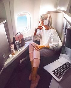 a woman sitting on an airplane with headphones