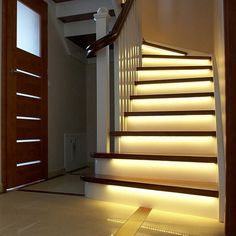 the stairs are illuminated with leds in this home entryway, which is lit up at night