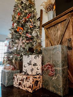 presents under the christmas tree in front of a wooden door