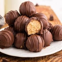 a white plate topped with chocolate covered peanut butter balls