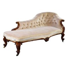 an antique style chaise lounge with beige velvet upholstered