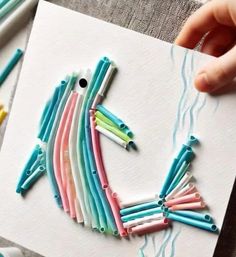 a person holding a piece of art made out of toothbrushes and paper clips