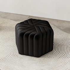 a black ottoman sitting on top of a rug