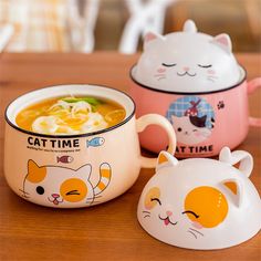 three bowls with cats on them sitting on a table