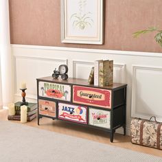 a black and white dresser sitting on top of a wooden floor next to a wall