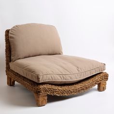 a wicker chaise lounge chair with cushion on it's back and legs