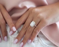 a woman's hands with pink manicures and a diamond ring