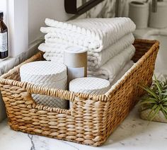 a wicker basket filled with lots of white towels