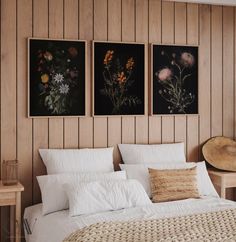 three paintings on the wall above a bed