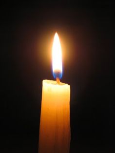 a lit candle is shown in the dark