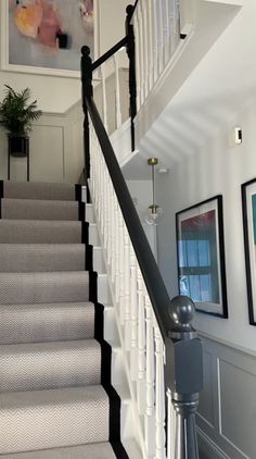 the stairs in this house have been painted white and black with contrasting carpet on them