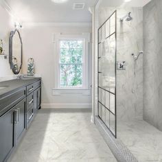 a large bathroom with two sinks and a walk - in shower next to a window