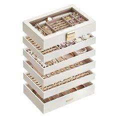 three white drawers with jewelry in them