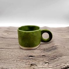 a green cup sitting on top of a wooden table