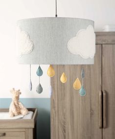 a baby crib mobile with raindrops and clouds hanging from it