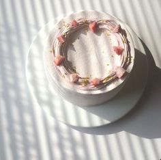 a cake with pink frosting sitting on top of a white plate