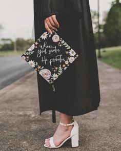 a woman in black dress and white heels standing on the street with her handbag