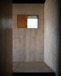 an empty room with a window and wooden shutters on the wall, next to a step